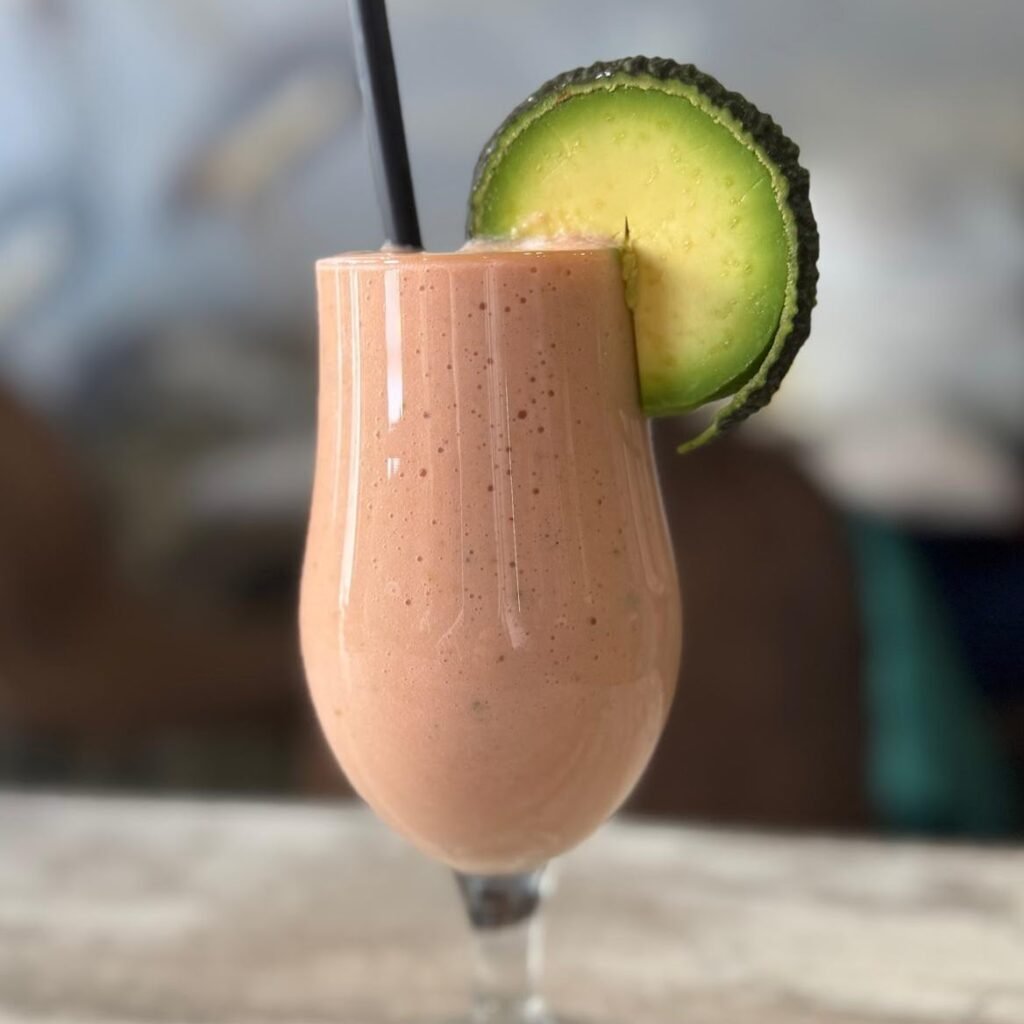 Batido saludable de aguacate y fresa servido en vaso alto con rodaja de aguacate en Cafetería Tanka's, Huelva.