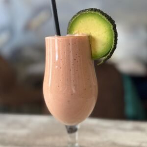 Batido saludable de aguacate y fresa servido en vaso alto con rodaja de aguacate en Cafetería Tanka's, Huelva.