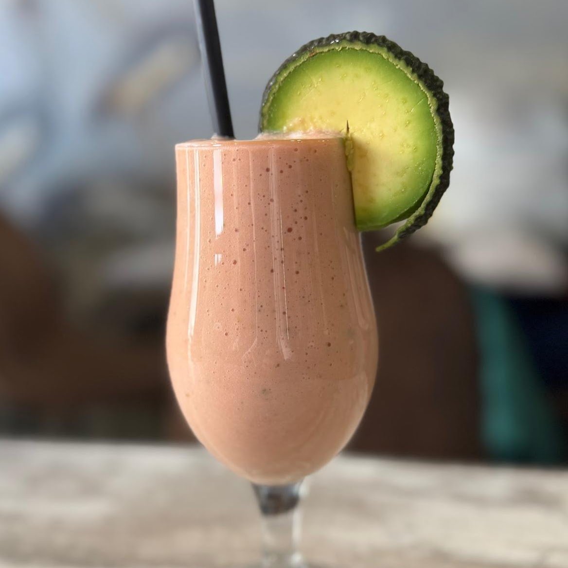 Batido saludable de aguacate y fresa servido en vaso alto con rodaja de aguacate en Cafetería Tanka's, Huelva.