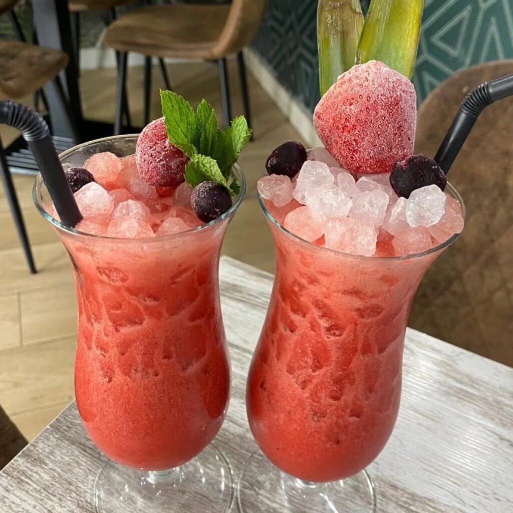 Cóctel rojo con hielo picado, frutas del bosque y menta en la cafetería Tankas