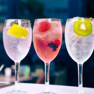 Tres copas de gin tonic con frutas naturales como limón, frutos rojos y kiwi