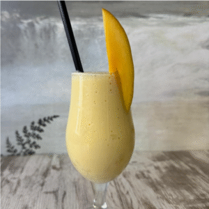 Zumo tropical de mango, piña y coco servido con rodaja de mango