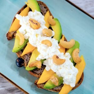 Tostada tropical con mango, aguacate, queso cottage y anacardos.