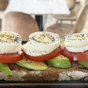 Tostada vegetariana con aguacate, tomate, queso de cabra y semillas de amapola.