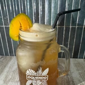 Té frío de melocotón servido con hielo y rodaja de fruta en jarra de cristal.