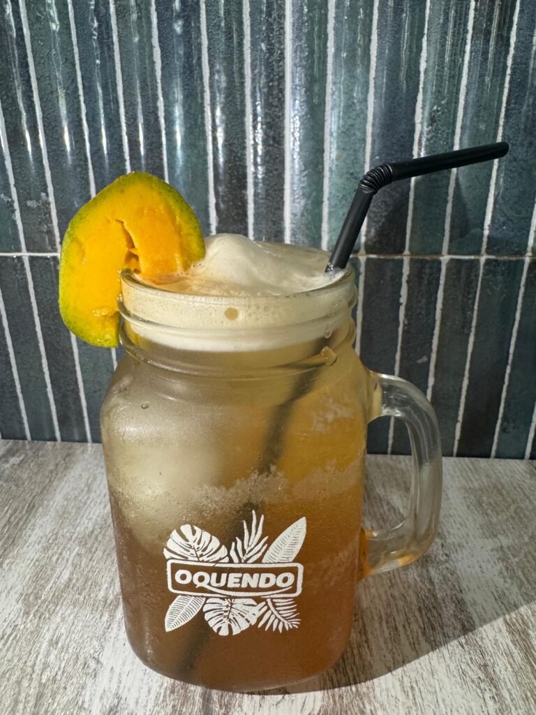 Té frío de melocotón servido con hielo y rodaja de fruta en jarra de cristal.