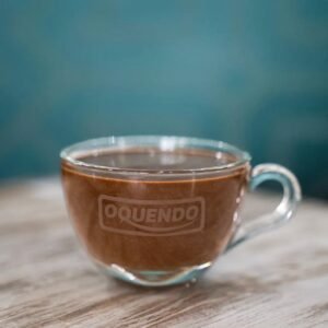 Chocolate caliente cremoso servido en taza de cristal en cafetería