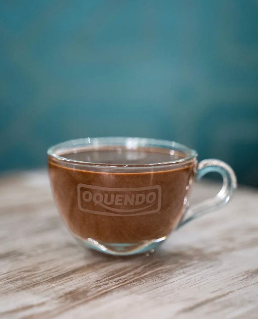Chocolate caliente cremoso servido en taza de cristal en cafetería