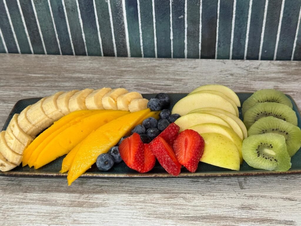 Plato de fruta fresca personalizable con mango, plátano, kiwi, manzana, fresas y arándanos en Tanka's La Boutique del Café en Huelva.
